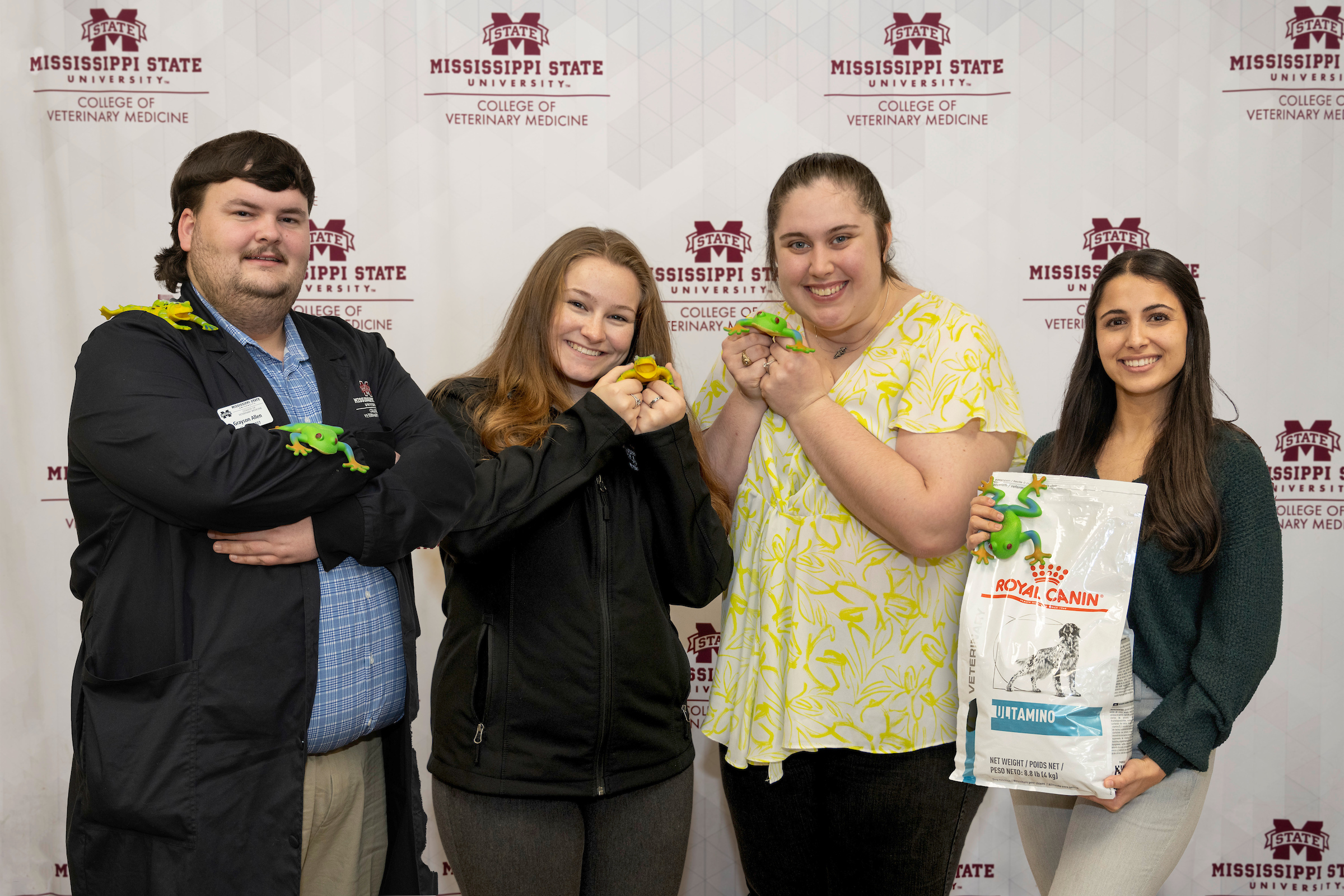 Several veterinary students hold frogs