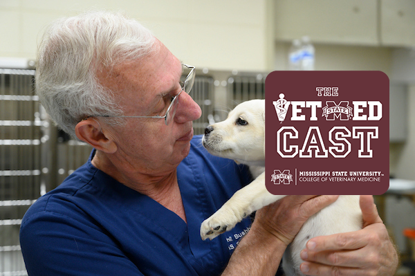 Dr. Phil Bushby and a puppy with the vet med logo.